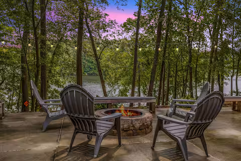 Four chairs around a firepit at dusk at the Virgilina Lake House, a Bello Homes short-term rental